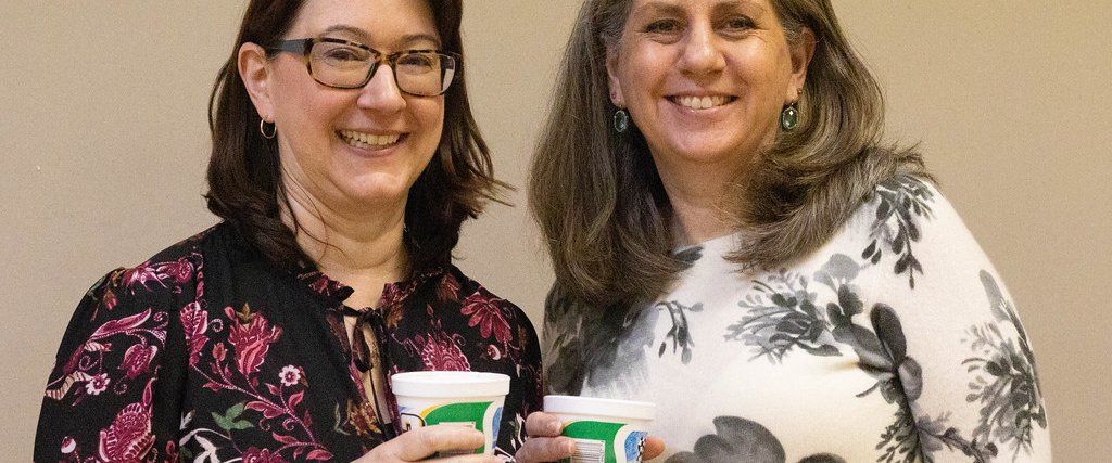 Two parishioners with cups of coffee in the Fellowship Hall.