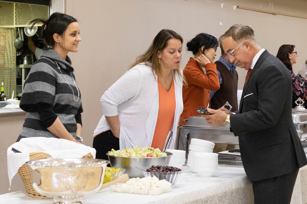 Parishioners serving themselves at a buffet table in the Fellowship Hall.