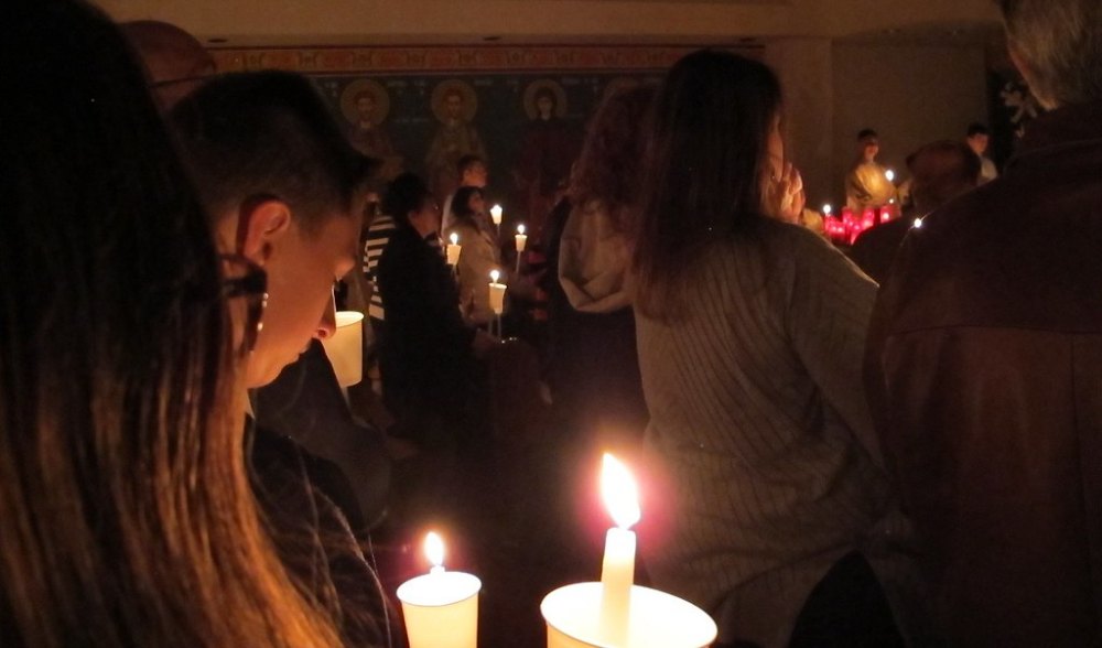 The congregation holding lit candles in the darkened church at the Paschal midnight service.